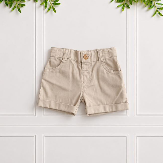 Boys stone cotton shorts with classic front pockets, belt loops and turned-up cuffs, displayed flat against a white panelled background.