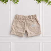 Back of boys stone cotton shorts with classic front pockets, belt loops and turned-up cuffs, displayed flat against a white panelled background.