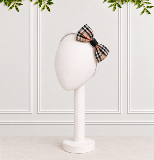 Stone Tartan Bow with black hoop on white Alice band. Beautifully presented against a white panelled background.