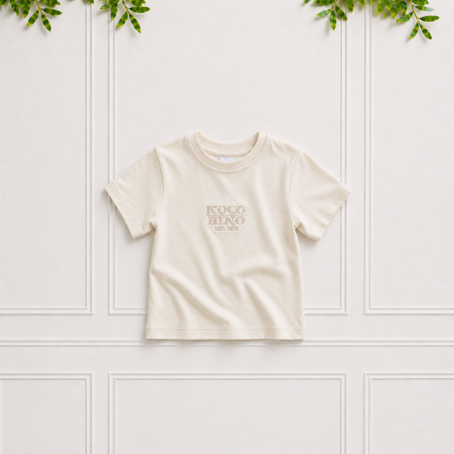 Cream boys' short sleeve T-shirt with tonal Koco Bino logo embroidery, soft natural creases and a classic crew neck for everyday comfort and style.