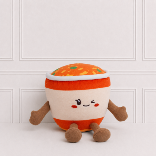 Cute noodle cup plush toy with a winking embroidered face, colourful noodle topping and soft arms and legs on a neutral background.