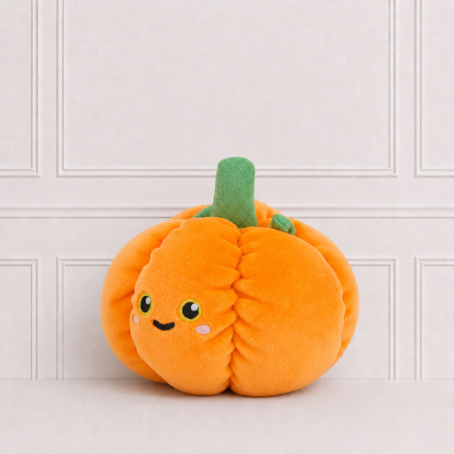 Plush pumpkin soft toy with a sweet embroidered face, bright orange fabric and green stem, beautifully photographed on a white studio backdrop.
