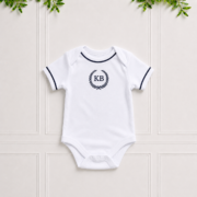 Navy baby vest in soft white cotton interlock with navy piping and elegant KB embroidery, perfect for newborn comfort and everyday wear.