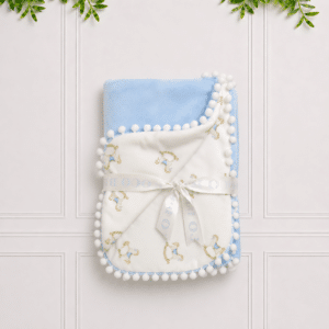 Soft blue baby blanket with a rocking horse print, plush backing and pompom trim, perfect for cuddles, naps and nursery style.