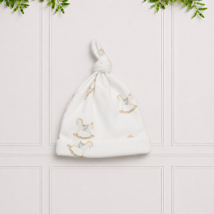 White baby knotted beanie with a charming rocking horse print, made from soft fabric to keep little heads cosy and comfortable.