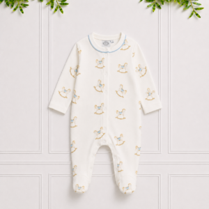 White baby footed onesie with a rocking horse print, blue piping and popper fastening, crafted for cosy comfort and sweet dreams.