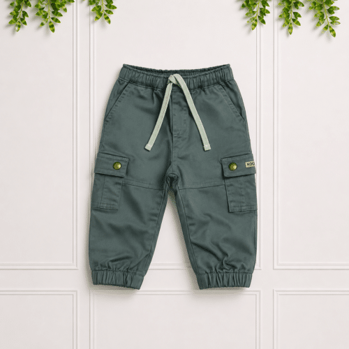 Green boys' cargo pants with elastic waistband, drawstring, cargo pockets and cuffed hems, displayed on a clean studio background with foliage.