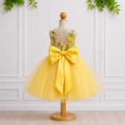 Jasmine yellow girls occasion dress shown from the back with sheer floral bodice, oversized satin bow and full layered tulle skirt.