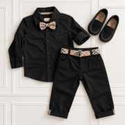 Boys’ black shirt and trousers with tartan bow tie, matching belt and black Batilas loafers styled in a smart outfit.