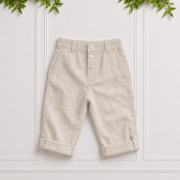 Boys stone linen pants with a tailored fit, front pockets, button fastening and convertible roll-up cuffs on a neutral studio background.