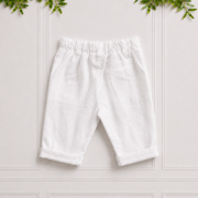 Back view of boys white linen pants featuring belt loops, rear pocket and convertible roll-up cuffs, displayed against a clean neutral studio background.