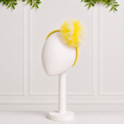 Girls yellow alice band with a delicate tulle pompom detail, perfect for adding a cheerful finishing touch to party and special occasion outfits.