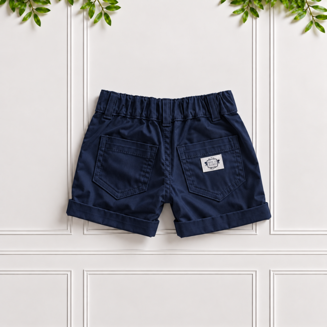 Boys Navy Cotton Shorts by Koco Bino, showing the elasticated back waistband, belt loops, two back pockets, branded label and neat turn-up hems.