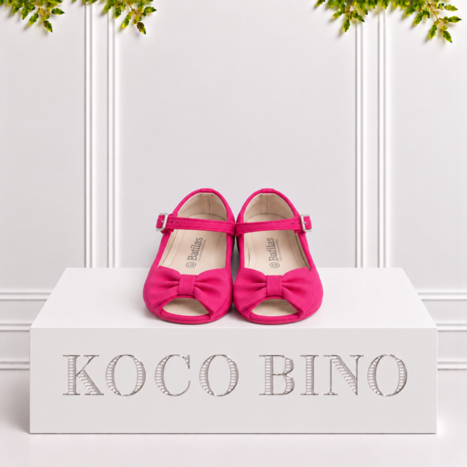 Fuchsia girls’ fabric Mary Jane sandals with bow detail, open toe, buckled straps, cream Batilas insoles and flat pink soles.